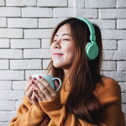 Smiling woman relaxing at home with a cup of coffee or tea by the window, enjoying a mindful caffeine break.