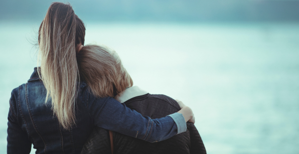 A woman embracing an Alzheimer's caregiver, offering her support.